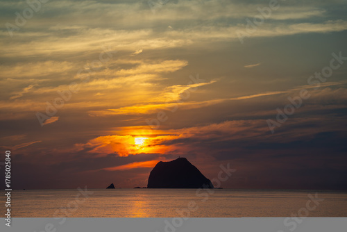 A breathtaking sunrise video from Waishuangxi Beach Keelung Taiwan. The sun rises over Keelung Islet creating a mystical and dramatic sky with golden orange tones.