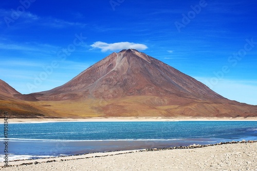 Tableau sur toile Lenticular cloud covers summit crater of colorful stratovolcano Cerro Licancabur, saline lake Laguna Verde at foot of mountain in Eduardo Avaroa Andean Fauna National Reserve in Cordillera Occidental