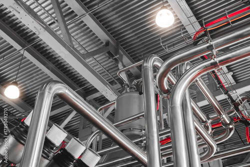 Obraz na plátně Stainless steel pipes attached to stainless steel tank with industrial food production machine, industrial concept background