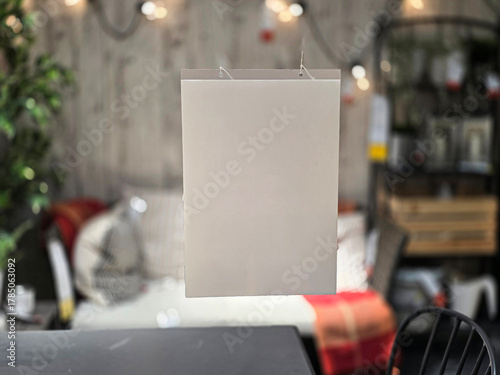 Mockup from blank piece of paper is suspended in a store with various decorations