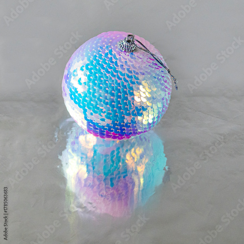 Christmass ball with shiny disko decoration on a reflective surface