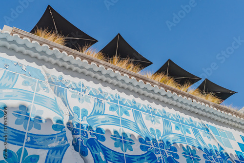 Traditional tiled wall with modern black umbrellas above