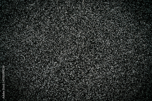 Fototapeta Naklejka Na Ścianę i Meble -  Texture of asphalt surface with small gravel stones. Dark rough road background with detailed grainy pattern. Close-up. Selective focus.