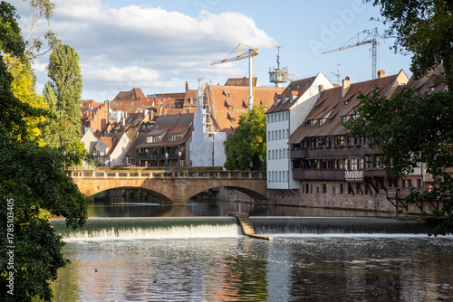 Traditional Bavarian buildings along the Pegnitz River in Nuremberg, Germany, reflecting on calm waters and showcasing classic architecture in a charming historic setting.