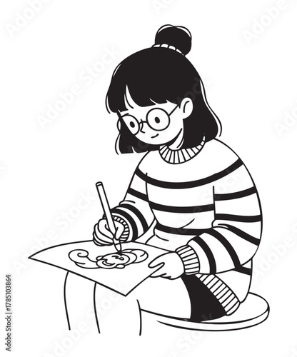 Young asian female artist with glasses, wearing a striped sweater, focuses intently on drawing while seated on a circular cushion.