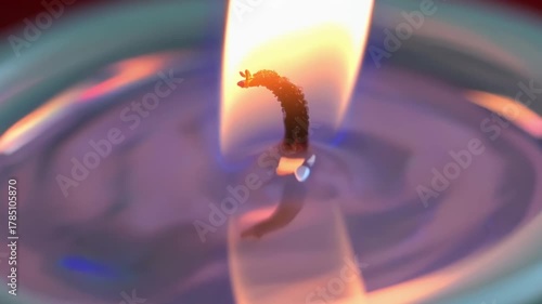 Candle flame with colorful reflections on wax surface creating mesmerizing patterns. concept of tranquility, meditation, peaceful ambiance.