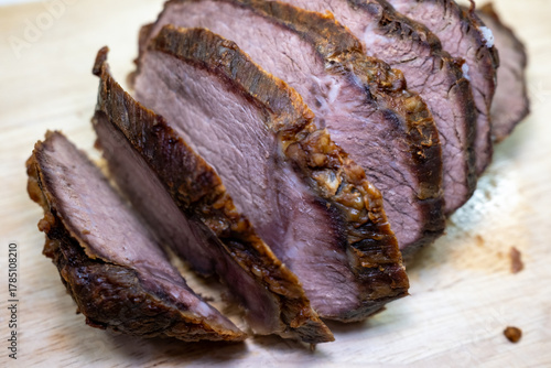 Foto Close-up of delicious, tender sliced roast beef on a wooden cutting board