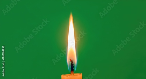 Vibrant candle flame flickers with warmth and light against a bold green background