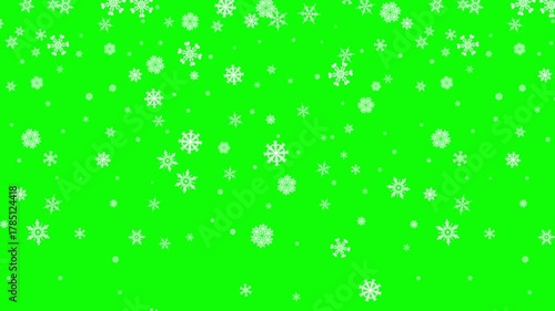 Festive winter background featuring delicate white snowflakes falling against a vibrant green backdrop creating a cheerful holiday atmosphere