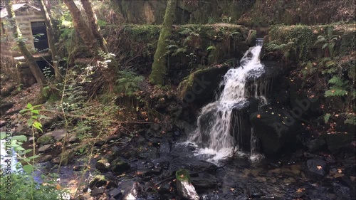 Waterfall of a water channel with abandoned and aged mills on the Jugueiros trail in the city of Felgueiras in northern Portugal, Europe, autumn setting with falling leaves