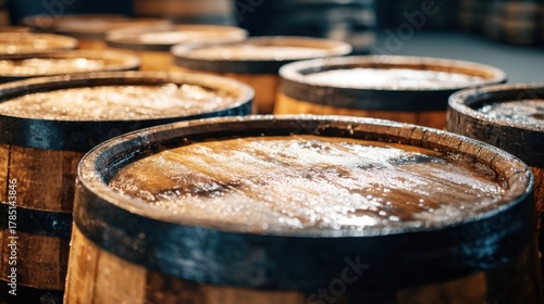 Wallpaper Mural Row of wooden barrels glistening with moisture in a dim warehouse, showcasing craftsmanship and the storage of beverages in a rustic setting during the late afternoon. Torontodigital.ca