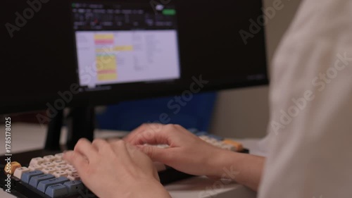 Hands input data swiftly, Closeup of fingers editing spreadsheet details, Person rapidly typing on vibrant keyboard while managing data on colorful digital display