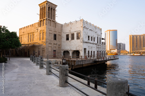 Traditional Emirati wind tower architecture glowing in evening light beside a creek, symbolizing Dubai heritage and timeless beauty. 