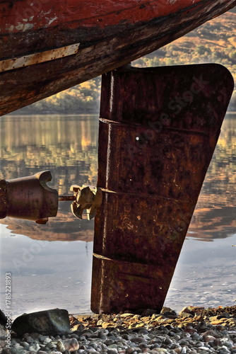 Rusty remains of the rudder sheet and propeller (with no blades) of the Golden Harvest shipwreck, aground on a pebble beach. Fort William-Scotland-060