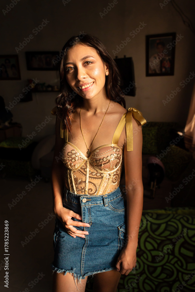 Fototapeta premium Portrait of a happy young Hispanic woman standing and looking at the camera inside her home in Neiva, Huila, Colombia. Concept of happiness and Colombian people