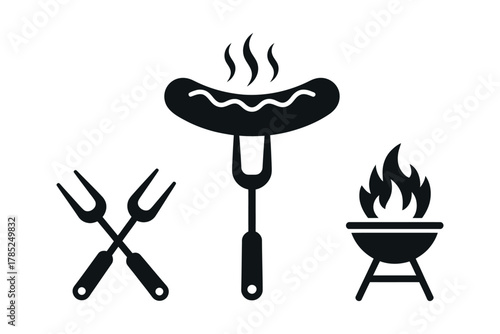 A grilled sausage on a fork with grilling tools and a barbecue grill