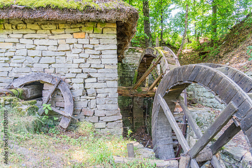 Фотография Ancient Central European village, rustic water wheel, dark wood, weathered spoke