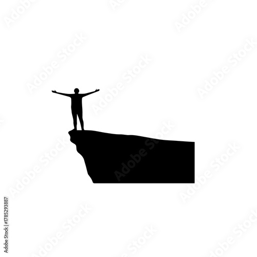 Man Standing on Cliff with Arms Open.