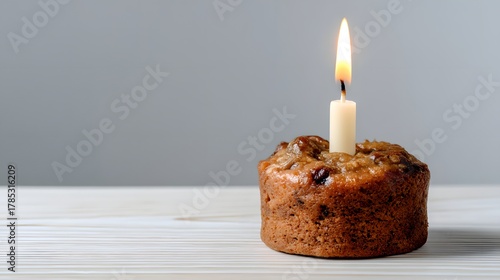 Birthday cake with a single candle and a rustic wooden background