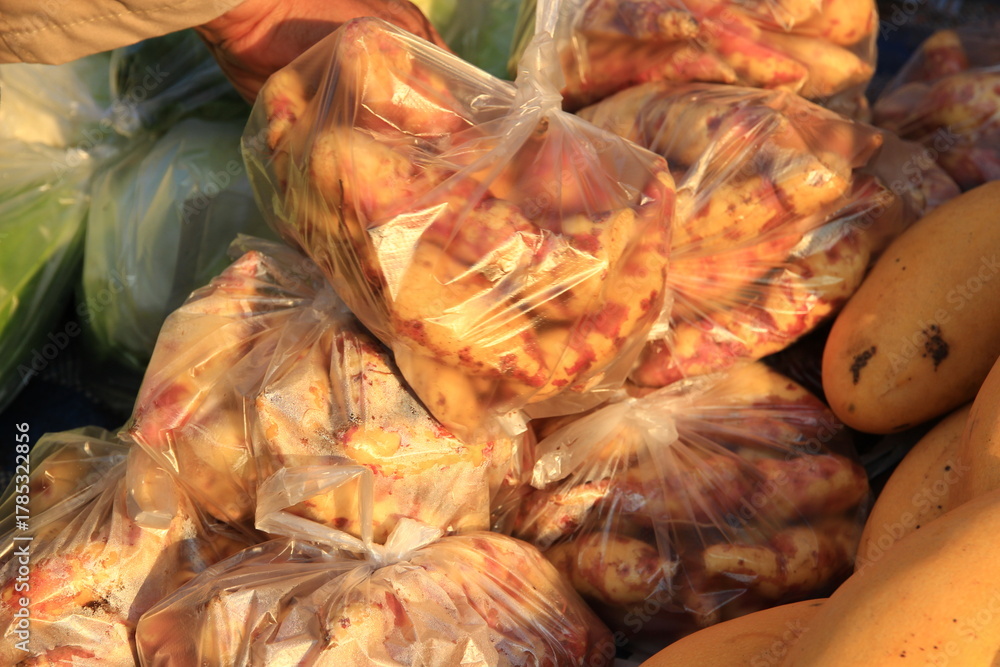 Fototapeta premium Many bags of sweet potatoes waiting to be sold in the market.