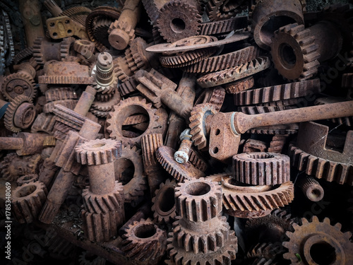 Rusty gears piled up in an industrial scrapyard