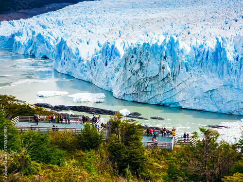 Majestic Perito Moreno Glacier with snow-capped mountains in Patagonia, Argentina. Vivid blue tones of the ice contrast with the dark slopes, highlighting the raw beauty of nature.