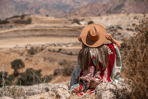 Woman holding her hat viend saqsayhuaman in Cusco Peru