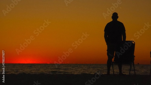 silhouette of a man sitting on the beach