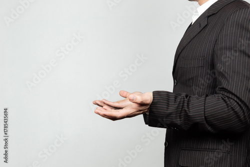 a businessman on suit at the right side of the screen doing a confused expression with his hands and a white background