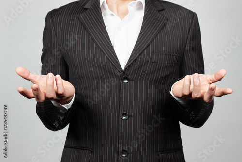 a businessman on suit doing a confused expression with his hands an a white background