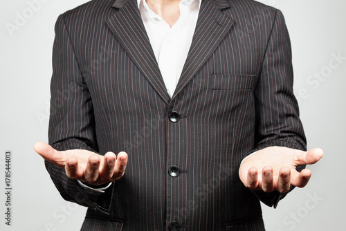 a businessman on suit with his both hands in front of him ready to hold something