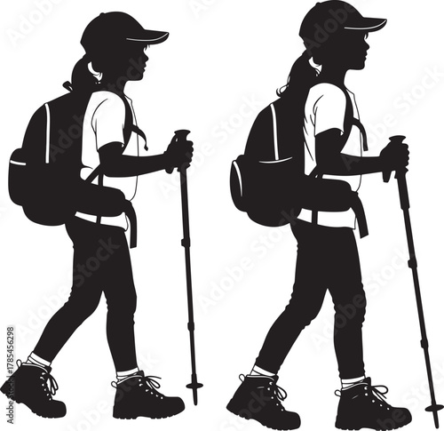 Two girls hiking with backpacks and trekking poles silhouette