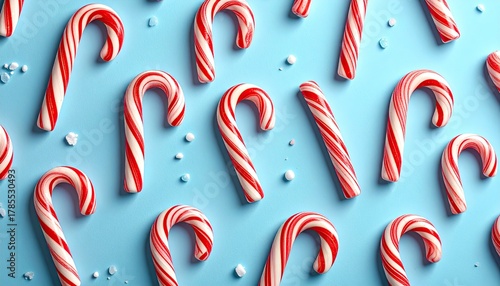 Candy canes arranged on a blue background, sprinkled with sugar