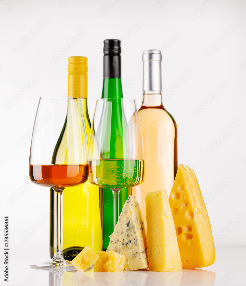 Naklejka premium Assorted cheeses and wine on white background