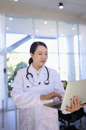 female doctor working with laptop in hospital.