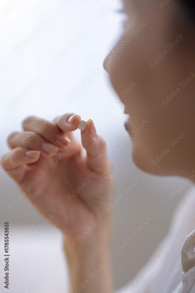 Naklejka premium Close-up of a pill held between fingers