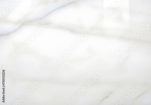 Elegant white marble texture with subtle gray veining, featuring a smooth reflective surface and a bright light highlight