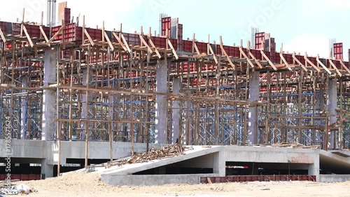Construction building site structure framework with concrete and steel, unfinished development of industrial architecture, exposed columns, wooden scaffolding, steel reinforcement, large scale