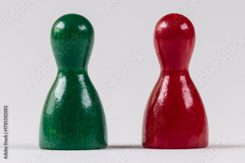 two wooden game pieces in green and red