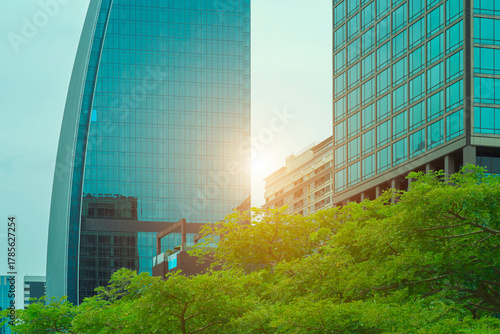 Financial office building a sustainable glass building with trees reduces heat and carbon dioxide. Office buildings with a green environment save energy and allow employees to relax.