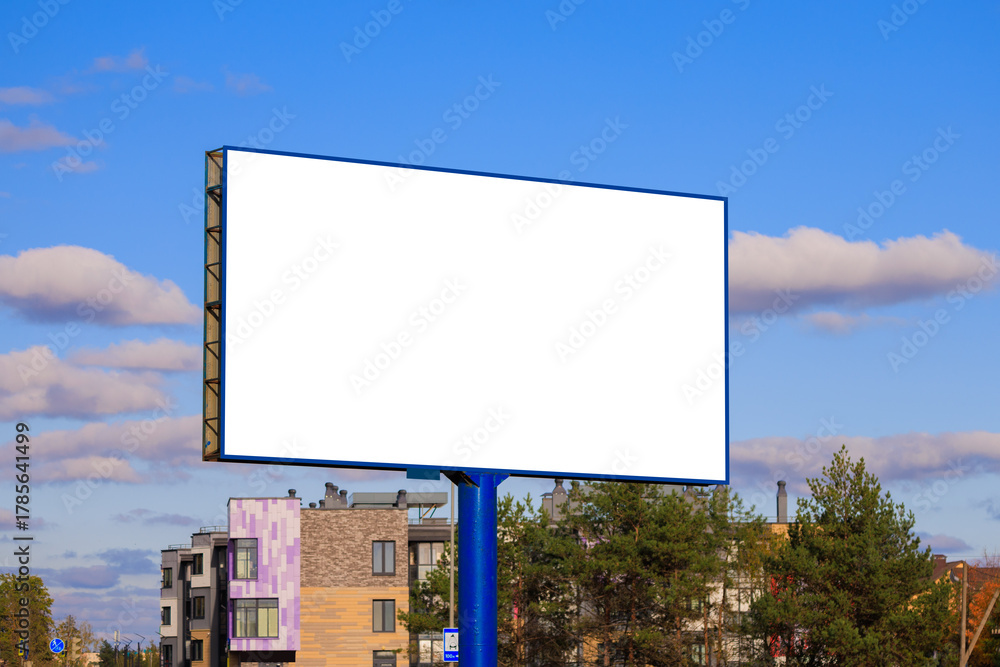 Fototapeta premium Advertising billboard along the road in the city on a sunny day. Background for design.
