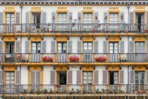 Traditional Apartment Building Facade with Numbered Doors and Flower Balconies