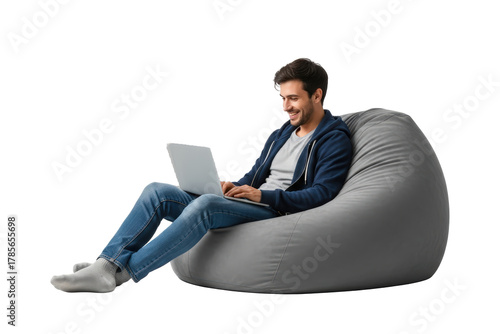 Smiling Man In Blue Hoodie And Jeans Sits On A Grey Bean Bag Chair Working On A Laptop Computer Isolated On Transparent Background