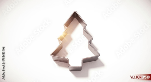 Sparkling metallic Christmas tree cookie cutter casting a warm shadow, perfect for festive baking and holiday crafting projects.