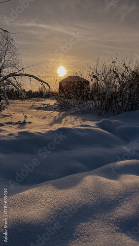 winter sunset in village, old house on the background 