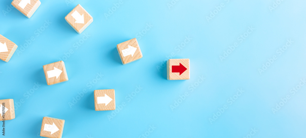 Naklejka premium Business competition, leadership concept. wooden blocks with red arrow on blue background