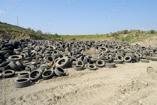 huge, sprawling dump site filled with thousands of black, discarded rubber tires piled high in an outdoor landscape. This image represents tire waste, pollution, and the need for recycling.