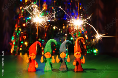 Figures of colorful dwarfs made of plasticine and sparklers.