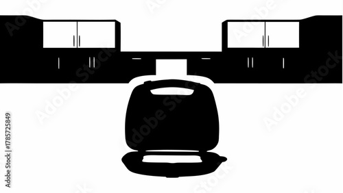 Black and white kitchen interior featuring cabinets and a waffle maker on the countertop surface area silhouette