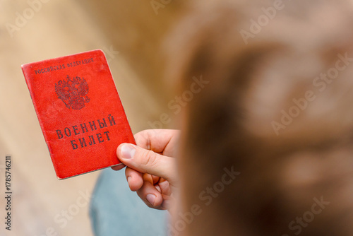 Fotomural A man holds a Military ID citizen of the Russian Federation, the concept of mobilization in Russia